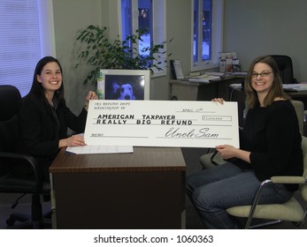 A Smiling Woman Receives An Oversized Tax Refund Check.