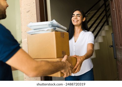 Smiling woman receiving a stack of packages from a delivery man at her front door - Powered by Shutterstock