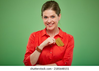 Smiling Woman In Red Shirt Pulls Credit Card Out Of Her Pocket, Isolated On Green.