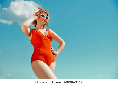 Smiling woman in red swimsuit with white sunglasses, hand on her hip, enjoying sunny day. Vintage beach style. Concept of hot summer holiday, weekends, vacation, relaxation. - Powered by Shutterstock