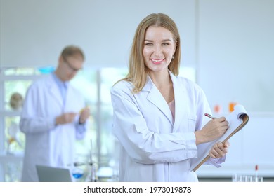 Smiling Woman Scientist With Scientist Team Workers Standing In The Laboratory, Covid-19.