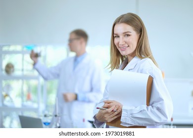 Smiling Woman Scientist With Scientist Team Workers Standing In The Laboratory, Covid-19.