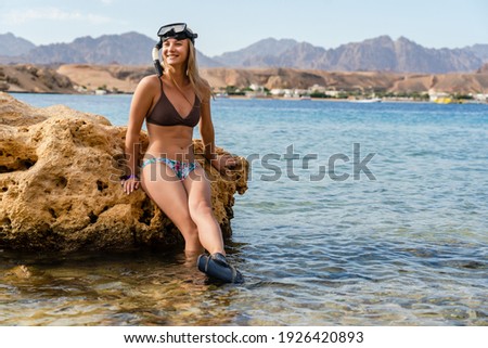 Smiling woman in scuba mask having fun in the beach cliff