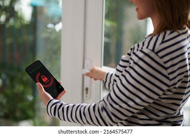Smiling Woman Setting Home Security System With Help Of Mobile Application