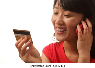 Smiling Woman shopping on-line with credit card and cellphone