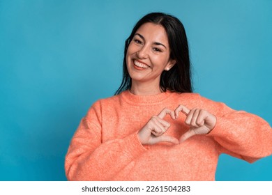 Smiling woman showing hearth sign