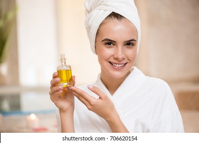 Smiling Woman Showing Little Bottle With Massage Body Oil