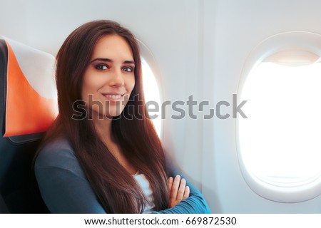 Smiling Woman Sitting By the Window on An Airplane - Aircraft passenger feeling excited for the flight
