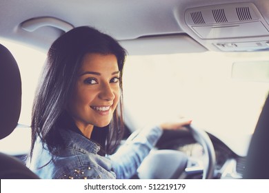 Smiling Woman Sitting In A Car And Looking Back. Toned Image