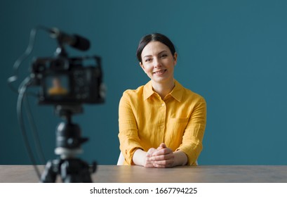 Smiling Woman Sitting In Front Of A Camera And Making A Video Blog