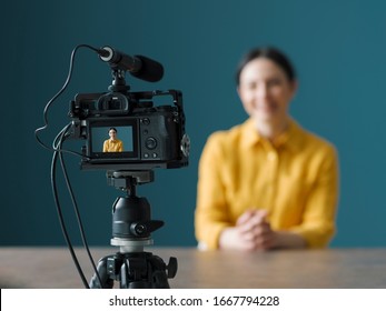 Smiling Woman Sitting In Front Of A Camera And Making A Video Blog