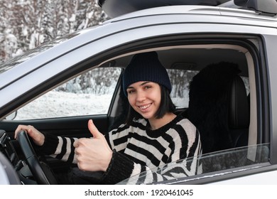 Smiling Woman Sitting Inside Car And Showing Thumb Up Sign And Holding Steering Wheel.