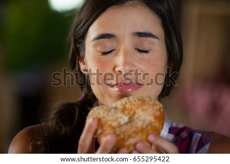 Smiling woman smelling a bread at counter in market
