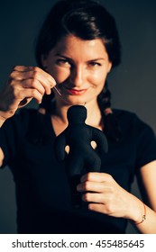 Smiling Woman Stabbing A Needle In A Textile Doll As A Revenge Towards Ex Lover