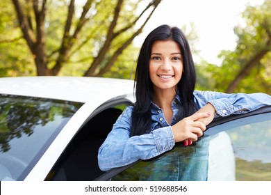 Smiling Woman Standing And Leaning On Car Door