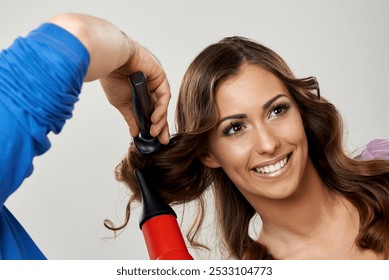 A smiling woman with styled hair enjoys a salon experience.  - Powered by Shutterstock