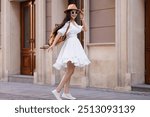 Smiling woman in stylish hat and sunglasses on city street