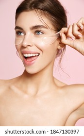 Smiling Woman Take-off Under Eye Collagen Patches, Nourish Gentle Skin With Gel Pads On Clean Skin, Concept Of Face Treatment And Anti-wrinkle Effect, Pink Studio Background.