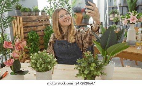 Smiling woman taking selfie with smartphone among indoor green plants in a bright flower shop. - Powered by Shutterstock