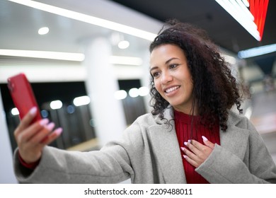 Smiling Woman Taking A Selfie Standing On A Subway Platform .