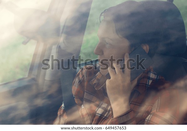 Smiling woman talking on\
mobile phone in car, satisfied adult female person during telephone\
conversation