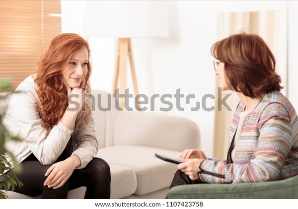 Smiling woman talking to a wellness\
coach to find motivation to achieve physical health\
goals