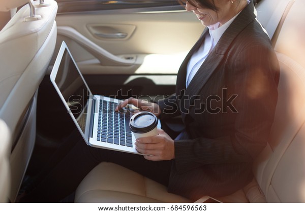 Smiling\
woman typing on computer with her morning\
coffee