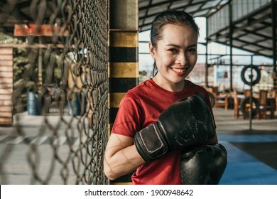 Smiling Woman Ultimate Fighter In Boxing Gloves Standing Near The Octagon Ring