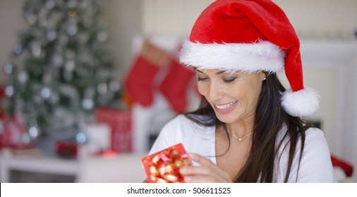 Smiling Woman Unwrapping Her Christmas Gift