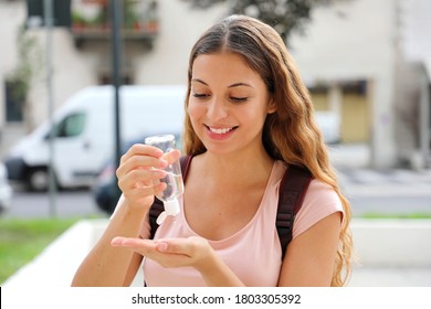 Smiling Woman Using Antibacterial Hand Sanitizer In City Street. Young Woman Washing Hands With Alcohol Gel Or Antibacterial Soap Sanitizer Outdoor.