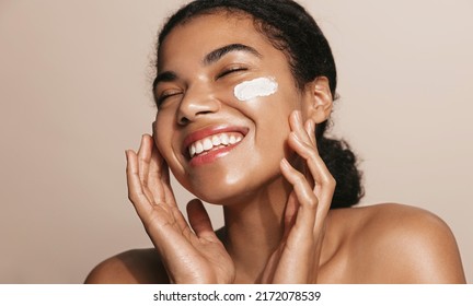 Smiling Woman Using Skincare Product. Female Taking Face Cream To Apply On Facial Skin