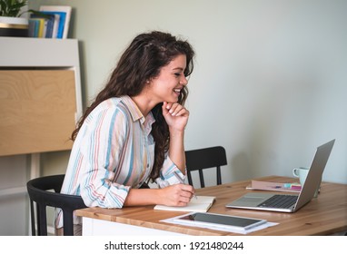 Smiling woman using video call on laptop at home.
Happy student studying online on laptop computer and taking notes - Shutterstock ID 1921480244