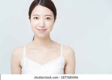 Smiling Woman Wearing A White Camisole