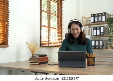 Smiling Woman Wearing Wireless Headphones Working Typing On Notebook Sit At Desk In Office Workplace. Enjoy E-learning Process, Easy Comfortable Application Usage, Listen Music During Workday Concept