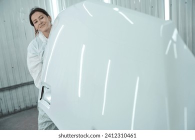 Smiling woman in white protective gear in a paint shop - Powered by Shutterstock