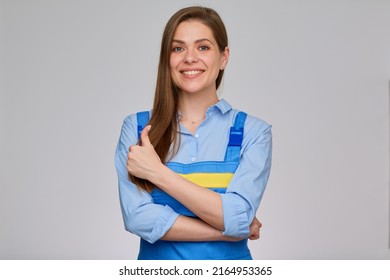 Smiling Woman Worker Plumber Or Elictrician In Blue Overalls With Yellow Stripe Shows Thunb Up. Isolated Portrait Of Happy Girl With Long Hair.