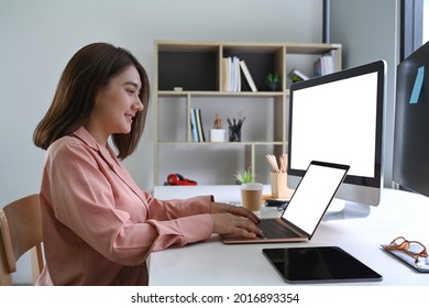 Smiling Woman Working With Multiple Devices At Home Office.