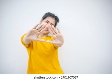 Smiling woman in yellow sweater showing Triangle with two hands