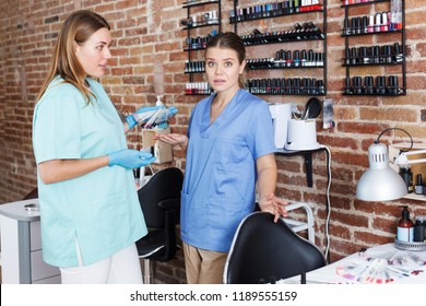 smiling women nail masters standing at workplace in modern nail salon - Shutterstock ID 1189555159