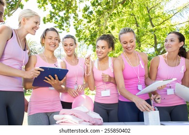 Smiling women organising event for breast cancer awareness on a sunny day - Powered by Shutterstock