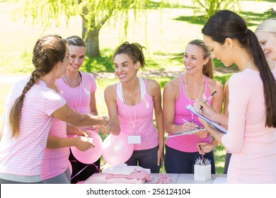 Smiling women organising event for breast cancer awareness on a sunny day - Powered by Shutterstock