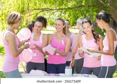 Smiling women organising event for breast cancer awareness on a sunny day