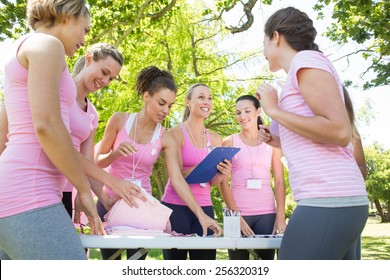 Smiling women organising event for breast cancer awareness on a sunny day - Powered by Shutterstock