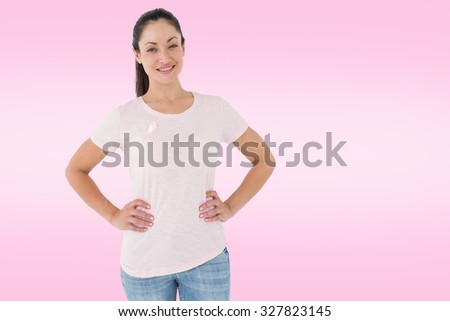 Smiling women in pink for breast cancer awareness against white background with vignette