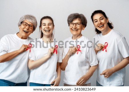Smiling women with pink satin ribbon symbolizing concept of illness awareness, expressing solidarity and support for cancer patients and survivors. Different generations of people