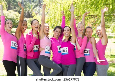 Smiling women running for breast cancer awareness on a sunny day - Powered by Shutterstock