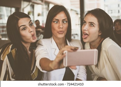 Smiling Women Taking Selfie Together Outdoors. Girls Making Funny Face.