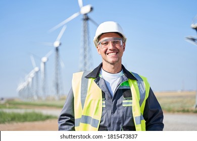 Smiling Worker Posing Against Windmill Background