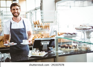 Smiling worker prepares breakfast at the bakery - Powered by Shutterstock