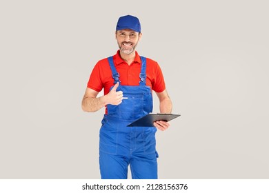 Smiling worker, repairman with documents in hands. Studio shot. A lot of copy space.